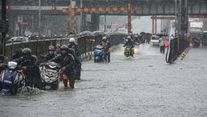 Motorists wade through a water logged street at Sion, Mumbai, on Wednesday.(PTI) Motorists wade through a water logged street at Sion, Mumbai, on Wednesday.(PTI)