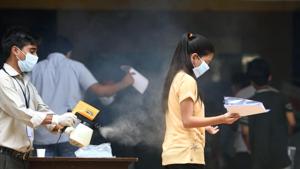 College staff sanitize a students before entering the exam center(Satish Bate/HT PHOTO) College staff sanitize a students before entering the exam center(Satish Bate/HT PHOTO)