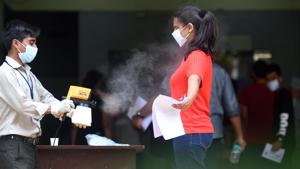 Staff sanitize a students before entering the exam center(Satish Bate/HT PHOTO) Staff sanitize a students before entering the exam center(Satish Bate/HT PHOTO)
