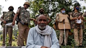A farmer rests as police officers stand guard during a protest against farm bills passed by parliament, at the Delhi-Uttar Pradesh border, in New Delhi, September 25, 2020.(REUTERS)