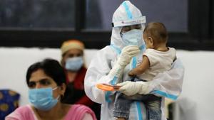 A medical worker in personal protective equipment (PPE) plays with a child of woman recovering inside a quarantine centre for the coronavirus disease (COVID-19) in New Delhi.(Reuters) A medical worker in personal protective equipment (PPE) plays with a child of woman recovering inside a quarantine centre for the coronavirus disease (COVID-19) in New Delhi.(Reuters)
