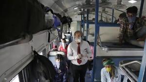A ticket collector checks the tickets of migrant workers siting inside a special train to return to Agra in Uttar Pradesh state.(AP File Photo) A ticket collector checks the tickets of migrant workers siting inside a special train to return to Agra in Uttar Pradesh state.(AP File Photo)