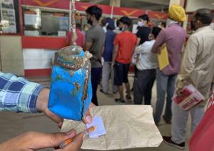 A resident using glue to seal a letter at the head post office in Ludhiana.(Gurpreet SIngh/HT) A resident using glue to seal a letter at the head post office in Ludhiana.(Gurpreet SIngh/HT)
