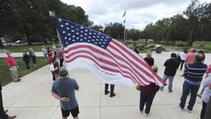 Veteran and Luzerne County employee Dino Ninotti holds a Flag of Honor during a 911 Ceremony Friday.(AP) Veteran and Luzerne County employee Dino Ninotti holds a Flag of Honor during a 911 Ceremony Friday.(AP)