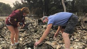 Kevin Conant and his wife, Nikki, sift through debris of their burnt home and business "Conants Wine Barrel Creations," after the Glass/Shady fire completely engulfed it, Wednesday.(AP) Kevin Conant and his wife, Nikki, sift through debris of their burnt home and business "Conants Wine Barrel Creations," after the Glass/Shady fire completely engulfed it, Wednesday.(AP)