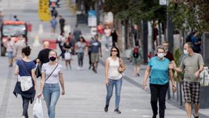 People wear face masks as they walk along a street in Montreal, Canada.(AP) People wear face masks as they walk along a street in Montreal, Canada.(AP)