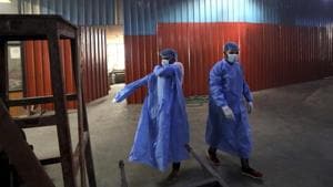 Workers put on personal protective suits before carrying the body of a Covid-19 victim for cremation in New Delhi.(AP) Workers put on personal protective suits before carrying the body of a Covid-19 victim for cremation in New Delhi.(AP)