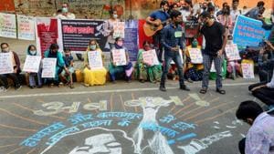 Demonstrators hold placards and stand near a mural on a street as they protest against the alleged gang-rape of a 19-year-old Dalit woman in Hathras (UP) in New Delhi on Sunday.(PTI Photo) Demonstrators hold placards and stand near a mural on a street as they protest against the alleged gang-rape of a 19-year-old Dalit woman in Hathras (UP) in New Delhi on Sunday.(PTI Photo)