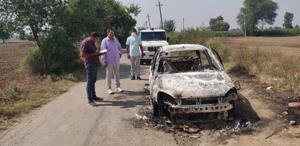 Investigators at the site where the car of the trader was burnt near Bhatla village at Hansi in Hisar on Tuesday night.(HT Photo)
