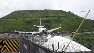 Officials stand by the debris of the Air India Express flight that skidded off a runway while landing in Kozhikode, Kerala.(AP) Officials stand by the debris of the Air India Express flight that skidded off a runway while landing in Kozhikode, Kerala.(AP)