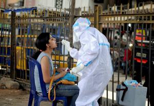 A health worker wearing a PPE kit collects a sample from a woman for the COVID-19 Rapid Antigen Test, at a city market in Bengaluru.(PTI) A health worker wearing a PPE kit collects a sample from a woman for the COVID-19 Rapid Antigen Test, at a city market in Bengaluru.(PTI)