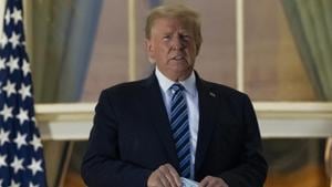 US President Donald Trump holds his mask after removing it from his face as he stands on the Blue Room Balcony upon returning to the White House in Washington from the Walter Reed National Military Medical Center in Bethesda, Md. He announced he tested positive for the coronavirus on October 2.(AP photo) US President Donald Trump holds his mask after removing it from his face as he stands on the Blue Room Balcony upon returning to the White House in Washington from the Walter Reed National Military Medical Center in Bethesda, Md. He announced he tested positive for the coronavirus on October 2.(AP photo)