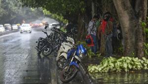 People take shelter under a tree while it rains, at Mathura Road in New Delhi.(Biplov Bhuyan/HT PHOTO) People take shelter under a tree while it rains, at Mathura Road in New Delhi.(Biplov Bhuyan/HT PHOTO)