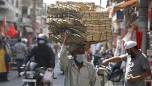 An Indian villager wearing a face mask as a precaution against the coronavirus sells his ware at market in Jammu, India.(AP) An Indian villager wearing a face mask as a precaution against the coronavirus sells his ware at market in Jammu, India.(AP)