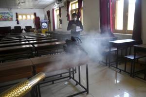 An MCD employee sprays disinfectant inside a classroom.(PTI) An MCD employee sprays disinfectant inside a classroom.(PTI)