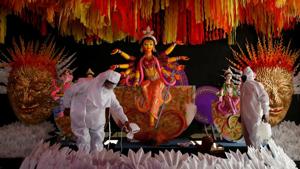 People wearing personal protective equipment (PPE) sanitise a ‘pandal’ or a temporary platform next to an idol of Goddess Durga ahead of the annual festival, amidst the coronavirus pandemic in Kolkata on Monday.(REUTERS PHOTO.) People wearing personal protective equipment (PPE) sanitise a ‘pandal’ or a temporary platform next to an idol of Goddess Durga ahead of the annual festival, amidst the coronavirus pandemic in Kolkata on Monday.(REUTERS PHOTO.)