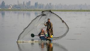 A fisherman casts his net in the Dal Lake as a woman rows the boat, in Srinagar, on October 11, 2020. (PTI Photo/S. Irfan)(PTI) A fisherman casts his net in the Dal Lake as a woman rows the boat, in Srinagar, on October 11, 2020. (PTI Photo/S. Irfan)(PTI)