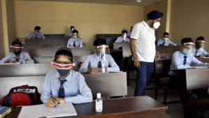 Students wearing face shields attend a class at a school that was reopened after remaining closed for months due to Covid-19 pandemic, in Patiala.(PTI)