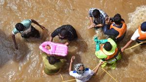 GHMC personnel carry an infant during an operation to move flood-affected people to a safer place, at Hafiz Baba Nagar in Hyderabad.(PTI)