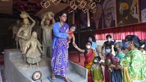 People look at the statues depicting migrant labors displayed at a community puja pandal ahead of the Durga Puja festival, in Kolkata.(PTI) People look at the statues depicting migrant labors displayed at a community puja pandal ahead of the Durga Puja festival, in Kolkata.(PTI)