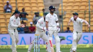 India's Virat Kohli looks on as Australian cricketers celebrate his dismissal during the first day of the second test match at Chinnaswamy Stadium in Bengaluru.(PTI) India's Virat Kohli looks on as Australian cricketers celebrate his dismissal during the first day of the second test match at Chinnaswamy Stadium in Bengaluru.(PTI)