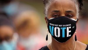 A woman wears a mask with a message urging voter participation while she waits in line to enter a polling place on the first day of the state's in-person early voting for the general election in Durham, North Carolina, US, October 15, 2020(REUTERS) A woman wears a mask with a message urging voter participation while she waits in line to enter a polling place on the first day of the state's in-person early voting for the general election in Durham, North Carolina, US, October 15, 2020(REUTERS)