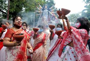 Women in Kolkata performing the 'Dhunachi' dance on the arrival procession of the Goddess Durga idol at their community puja pandal ahead of Durga Puja amid the coronavirus pandemic.(PTI) Women in Kolkata performing the 'Dhunachi' dance on the arrival procession of the Goddess Durga idol at their community puja pandal ahead of Durga Puja amid the coronavirus pandemic.(PTI)