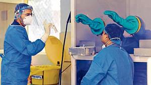 A health care worker gets ready to collect a swab sample at LNJP Hospital in New Delhi on Friday. A health care worker gets ready to collect a swab sample at LNJP Hospital in New Delhi on Friday.