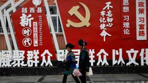 Ethnic Yi women walk past an installation featuring a logo of Communist Party of China at the Chengbei Ganen Community.(REUTERS) Ethnic Yi women walk past an installation featuring a logo of Communist Party of China at the Chengbei Ganen Community.(REUTERS)