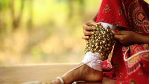 Close up of a young female kathak dancer tying ghungroo to her legs.(Getty Images) Close up of a young female kathak dancer tying ghungroo to her legs.(Getty Images)