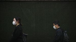 People wearing a face mask to help curb the spread of the coronavirus walk by a construction site in Beijing on Monday. Schools and kindergartens have been suspended and communities are on lockdown in Kashgar, a city in China's northwest Xinjiang region, after a spike in asymptomatic cases.(AP) People wearing a face mask to help curb the spread of the coronavirus walk by a construction site in Beijing on Monday. Schools and kindergartens have been suspended and communities are on lockdown in Kashgar, a city in China's northwest Xinjiang region, after a spike in asymptomatic cases.(AP)