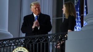 US President Donald Trump applauds US Supreme Court Associate Justice Amy Coney Barrett while posing with her on a White House balcony after she took her oath of office to serve on the US Supreme Court in Washington.(REUTERS) US President Donald Trump applauds US Supreme Court Associate Justice Amy Coney Barrett while posing with her on a White House balcony after she took her oath of office to serve on the US Supreme Court in Washington.(REUTERS)
