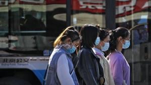 Women wearing face masks to help curb the spread of the coronavirus walk along a street in Beijing on Wednesday.(AP) Women wearing face masks to help curb the spread of the coronavirus walk along a street in Beijing on Wednesday.(AP)