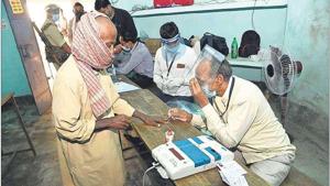 An election officer wears a face shield as a protective measure against Covid at a polling station in Paliganj on Wednesday.(AP Photo) An election officer wears a face shield as a protective measure against Covid at a polling station in Paliganj on Wednesday.(AP Photo)