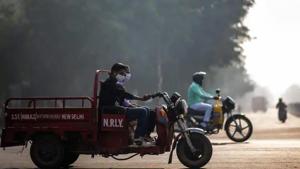 People wearing face masks ride along a street amid smoggy conditions in New Delhi on October 30.(AFP) People wearing face masks ride along a street amid smoggy conditions in New Delhi on October 30.(AFP)
