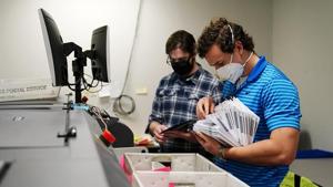 Workers organize mail-in ballots to be sorted for the 2020 General Election in the United States.(AP Phptp) Workers organize mail-in ballots to be sorted for the 2020 General Election in the United States.(AP Phptp)