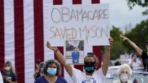 Adelys Ferro holds a sign in support of Obamacare as former President Barack Obama speaks while campaigning for Democratic presidential candidate former Vice President Joe Biden at Florida International University, Miami.(AP) Adelys Ferro holds a sign in support of Obamacare as former President Barack Obama speaks while campaigning for Democratic presidential candidate former Vice President Joe Biden at Florida International University, Miami.(AP)