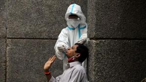 A healthcare worker wearing personal protective equipment (PPE) collects a swab sample from a man amidst the spread of the coronavirus disease (Covid-19), at a testing center in New Delhi.(Reuters) A healthcare worker wearing personal protective equipment (PPE) collects a swab sample from a man amidst the spread of the coronavirus disease (Covid-19), at a testing center in New Delhi.(Reuters)