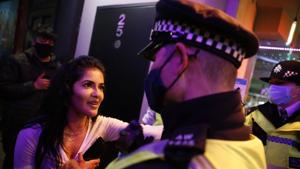 A police officer talks to a reveller in the street after the pubs closed in the Soho area of central London on November 4 on the eve of a second novel coronavirus lockdown.(AFP) A police officer talks to a reveller in the street after the pubs closed in the Soho area of central London on November 4 on the eve of a second novel coronavirus lockdown.(AFP)