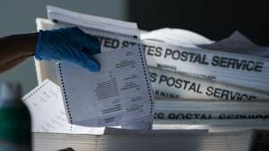 An election official wearing a protective mask counts absentee ballots for the 2020 Presidential election at State Farm Arena in Atlanta, Georgia, US.(Bloomberg) An election official wearing a protective mask counts absentee ballots for the 2020 Presidential election at State Farm Arena in Atlanta, Georgia, US.(Bloomberg)