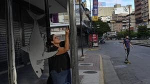 Artist Susan Applewhite attaches her recycled cardboard art onto a bus stop.(AP) Artist Susan Applewhite attaches her recycled cardboard art onto a bus stop.(AP)