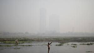 A man prays on the banks of the polluted Yamuna river amidst heavy smog in the morning in New Delhi.(REUTERS)