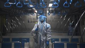 A railway worker in PPE coveralls sprays disinfectant in a local train coach in Kolkata, West Bengal, on Monday.(HT Photo) A railway worker in PPE coveralls sprays disinfectant in a local train coach in Kolkata, West Bengal, on Monday.(HT Photo)
