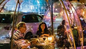 Customers dine in social distancing bubble tents at a restaurant in New York.(Bloomberg) Customers dine in social distancing bubble tents at a restaurant in New York.(Bloomberg)