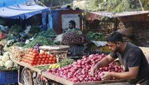A vegetable vendor awaits customers while arranging onions in his cart at a market in Prayagraj.(AP) A vegetable vendor awaits customers while arranging onions in his cart at a market in Prayagraj.(AP)