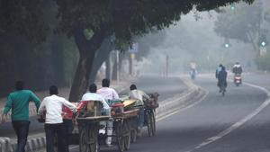Street vendors push their tri-cycle carts amid an atmosphere shrouded in smog, in New Delhi.(PTI) Street vendors push their tri-cycle carts amid an atmosphere shrouded in smog, in New Delhi.(PTI)