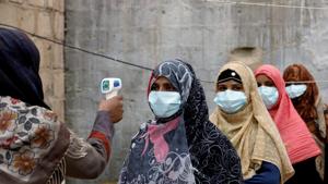 Women wear protective masks as they get their temperature checked as the spread of the coronavirus disease (Covid-19) continues, in Karachi, Pakistan.(Reuters) Women wear protective masks as they get their temperature checked as the spread of the coronavirus disease (Covid-19) continues, in Karachi, Pakistan.(Reuters)