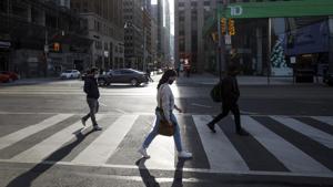 Pedestrians wearing protective masks cross a street in Toronto, Ontario, Canada, on November 13.(Bloomberg) Pedestrians wearing protective masks cross a street in Toronto, Ontario, Canada, on November 13.(Bloomberg)