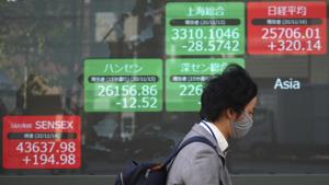 A man wearing a mask against the spread of the coronavirus walks past an electronic stock board showing Japan's Nikkei 225 and other Asian index at a securities firm in Tokyo.(AP) A man wearing a mask against the spread of the coronavirus walks past an electronic stock board showing Japan's Nikkei 225 and other Asian index at a securities firm in Tokyo.(AP)