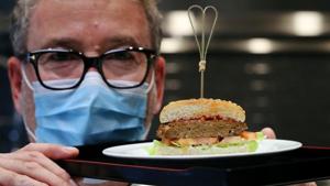 Chef Sam Brunschweiler wears a protective mask as he displays a pea protein-based hamburger with vegan juicy meat flavor, tomato, salad and sesame bun on a plate at flavour maker Givaudan's innovation centre in Kemptthal, Switzerland.(REUTERS) Chef Sam Brunschweiler wears a protective mask as he displays a pea protein-based hamburger with vegan juicy meat flavor, tomato, salad and sesame bun on a plate at flavour maker Givaudan's innovation centre in Kemptthal, Switzerland.(REUTERS)